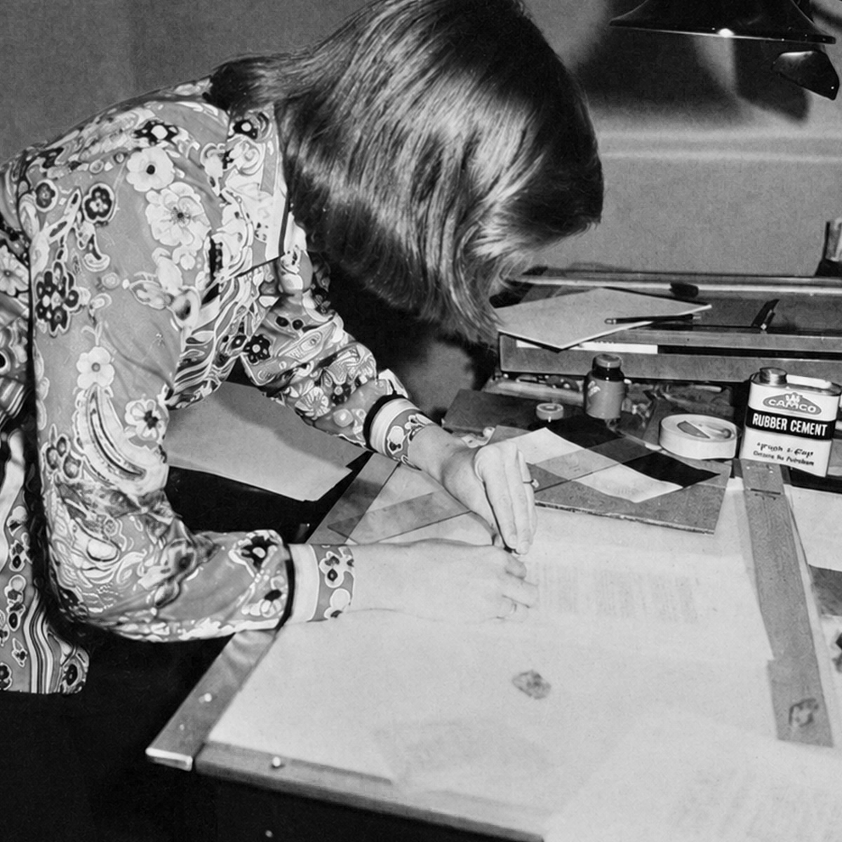 Black-and-white photograph from the archive of a woman working at a paste-up table.
